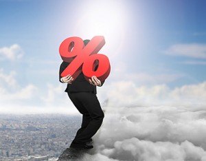 Man carrying red percentage sign on ridge with cloudscape cityscape