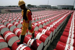 File photo of an employee of Indonesian oil company Pertamina walking on the top of drums at Jakarta's oil storage depot.